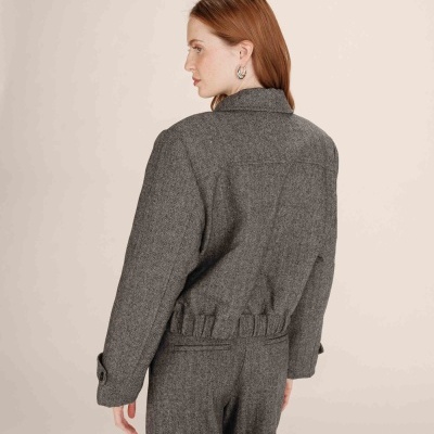 Casaco cinza padrão espinha de peixe com punhos abotoados e cintura elástica.