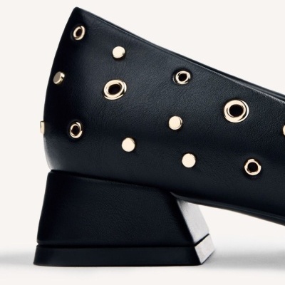 Sapato preto com detalhes metálicos dourados e salto baixo