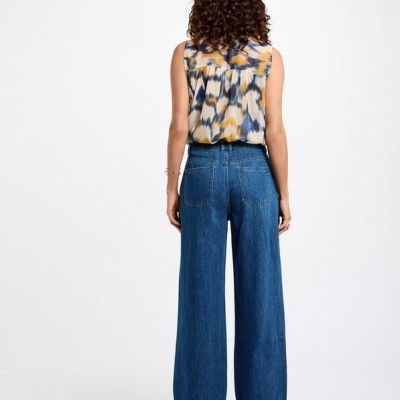 Top sem mangas colorido com calças de ganga azul largas vistas de costas