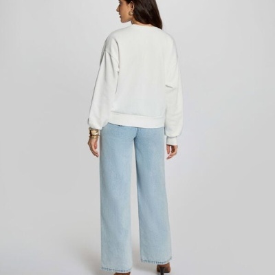 Mulher de costas com sweatshirt branca e calças de ganga azul claro