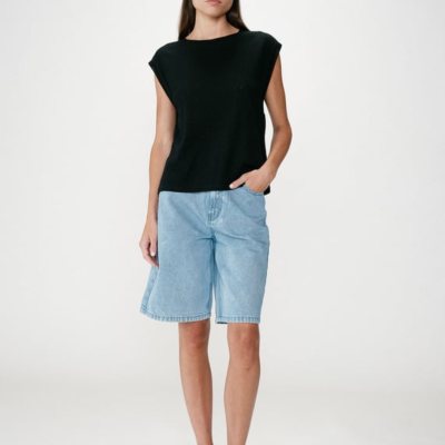 Mulher com t-shirt preta e calções de ganga azul claro.