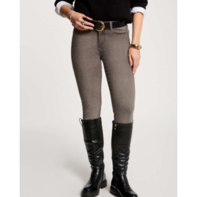 Calças justas cinza claro, cinto preto, botas pretas altas, roupa preta e branca