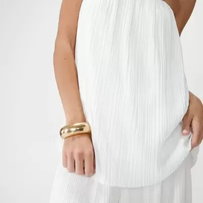 Vestido branco plissado e pulseira dourada no braço