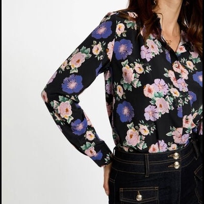Blusa floral preta e calças de ganga escuras com botões dourados