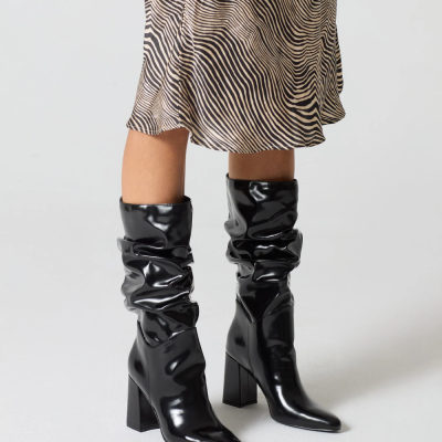 Botas pretas brilhantes com vestido padrão ondulado