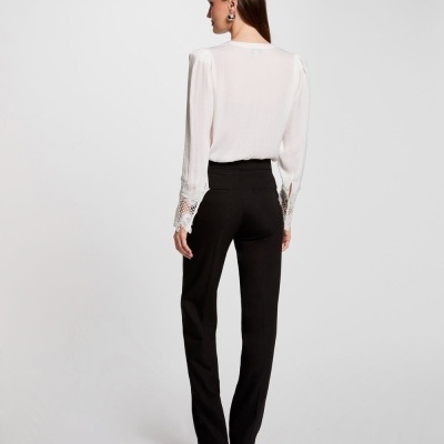 Mulher de costas com blusa branca e calças pretas