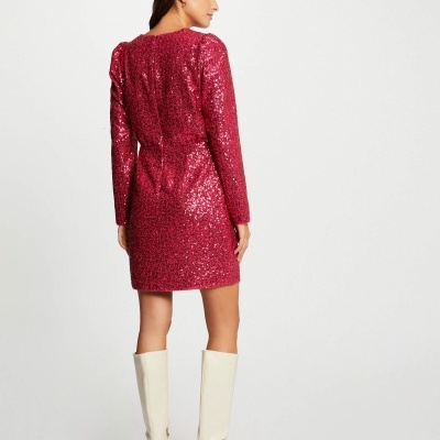 Vestido curto com lantejoulas cor de vinho e botas brancas.