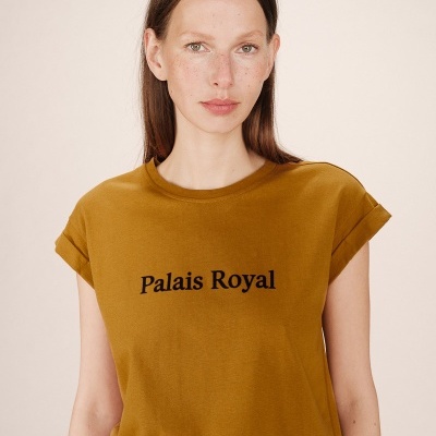 Mulher a usar t-shirt castanha com texto 'Palais Royal'