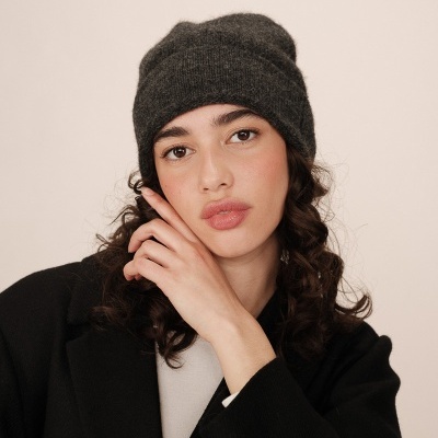 mulher com gorro cinzento escuro de malha e casaco preto