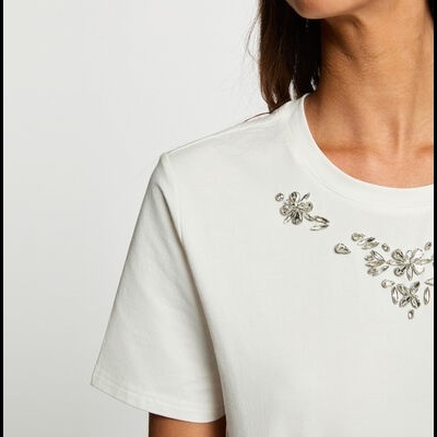T-shirt branca com pedras decorativas florais no peito