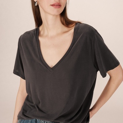 Mulher a usar camisola preta de manga curta com decote em V e calças de ganga azul clara