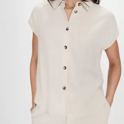 Conjunto de roupa claro em tecido semelhante a linho com camisa e calças.