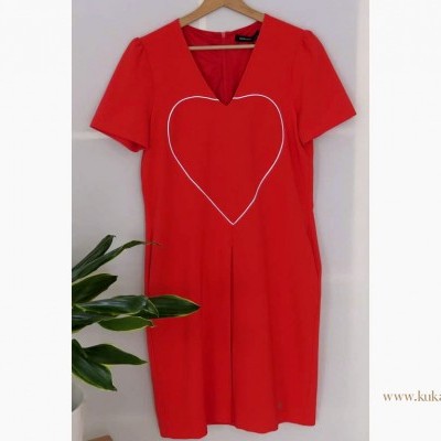 Vestido vermelho com coração branco pendurado num cabide