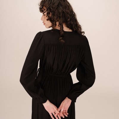 Vestido feminino preto com mangas compridas, visto de costas
