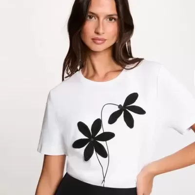 T-shirt branca com flores pretas aplicadas e saia preta