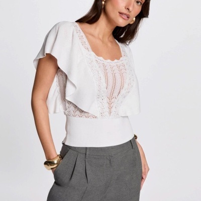 Blusa branca de renda com calças cinzentas em fundo branco
