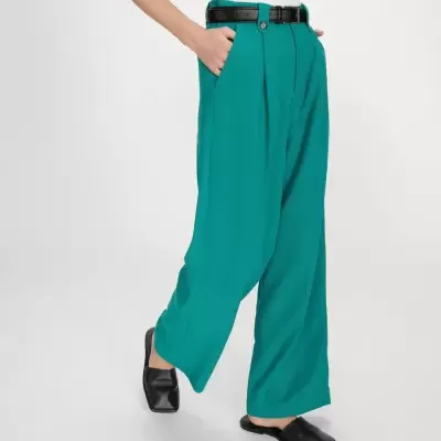 Calças largas verdes com cinto preto e sapatos baixos pretos