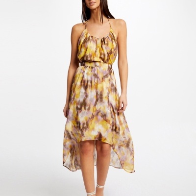 Vestido feminino amarelo e roxo com padrão abstrato e sandálias brancas
