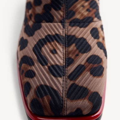 Bota com padrão animal print castanho e preto e sola vermelha