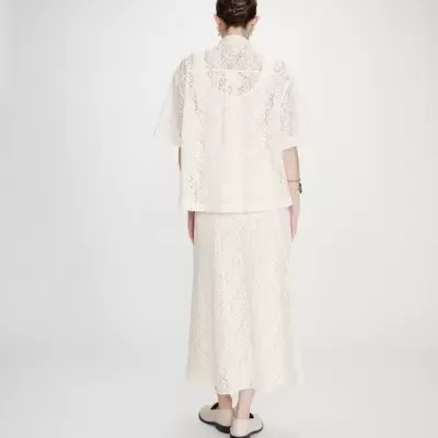 Conjunto feminino branco de renda com camisa de manga curta e saia comprida, vista de costas.