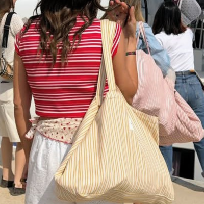 Mulheres com bolsas grandes às riscas em ambiente exterior