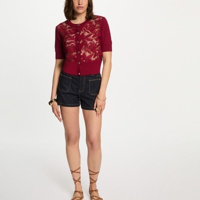 Mulher a usar camisola vermelha em renda, calções de ganga escura e sandálias castanhas de tiras finas