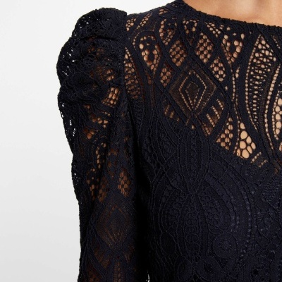 Top feminino de renda preta com padrão geométrico intricado e manga bufante