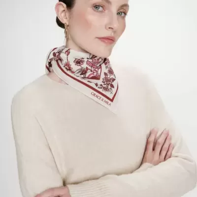Mulher com lenço floral branco e camisola creme de malha