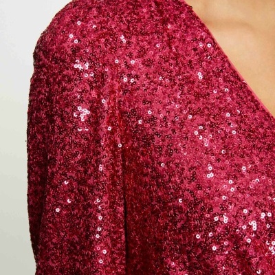 Roupa vermelha com lantejoulas brilhantes e decote em V