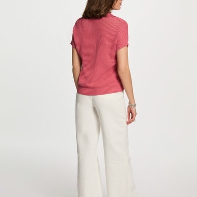 Mulher de costas com camisola rosa, calças brancas e sapatos brancos