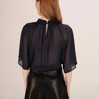 Blusa preta translúcida com calções pretos, vista de costas