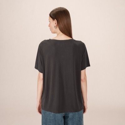 Mulher de costas a usar t-shirt preta de manga curta e calças de ganga azuis