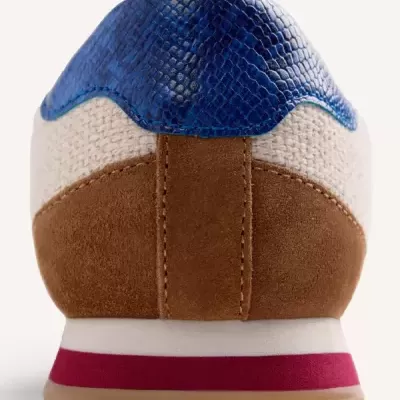 Ténis castanho, creme e azul com sola branca e vermelha visto de trás