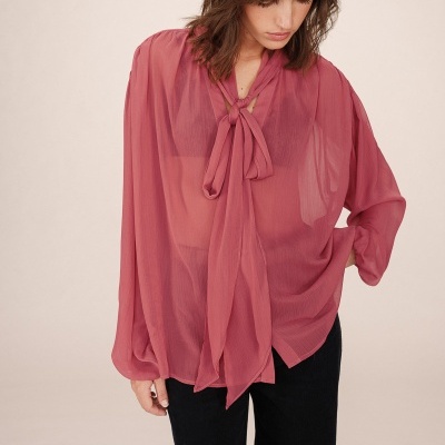 Blusa rosa transparente com laço e mangas largas, vista frontal com calças pretas