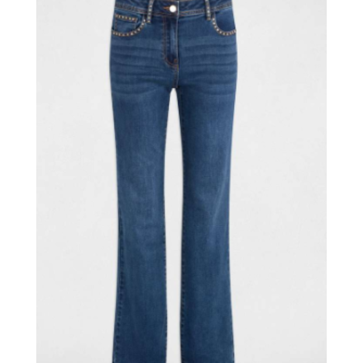 Calças de ganga azuis com rebites dourados numa superfície cinzenta