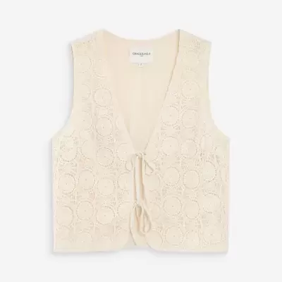 Top colete creme de crochet com padrão circular e amarrações frontais