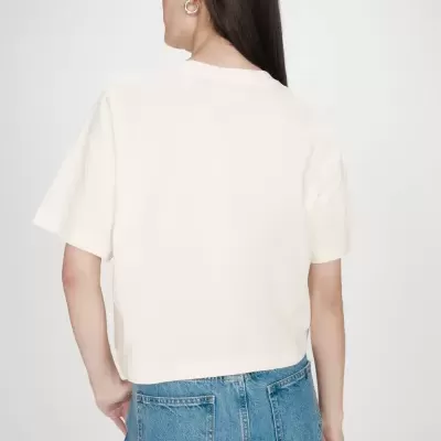 Pessoa de costas com t-shirt branca curta e jeans azuis