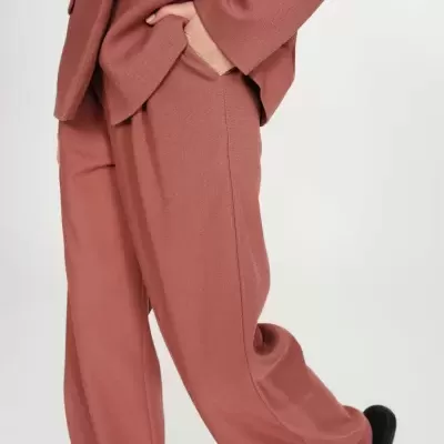 Calças rosa antigo largas com casaco combinando e sapatos pretos