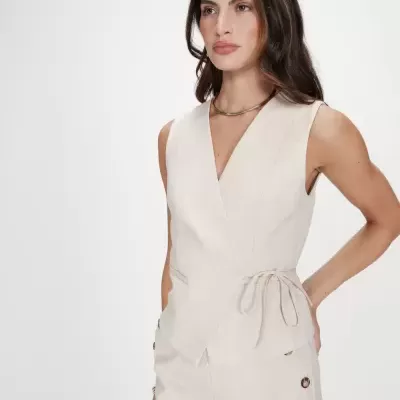 Conjunto de mulher bege claro colete e calças com laço lateral do colete