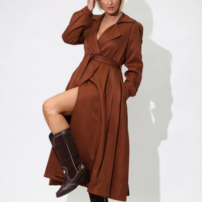 Mulher a usar casaco comprido castanho e botas castanhas com fundo branco