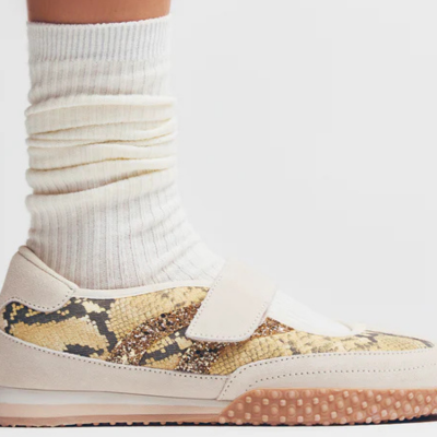 Ténis com padrão animal print e sola castanha, usado com meias brancas caneladas