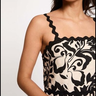 Top com padrão floral preto em fundo creme e alças onduladas pretas