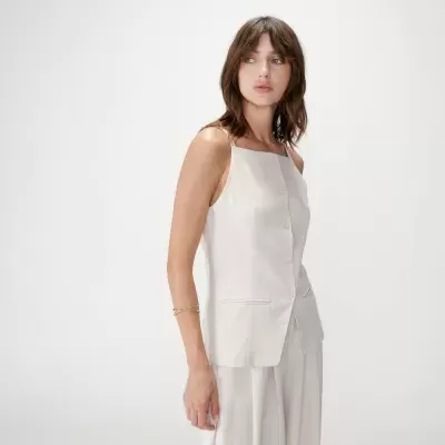 Mulher com conjunto branco composto por top e calças largas