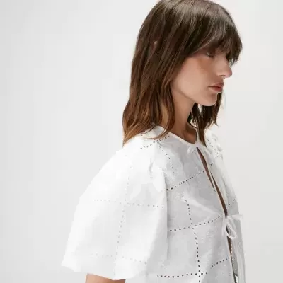 Blusa branca bordada com mangas bufantes e laços frontais