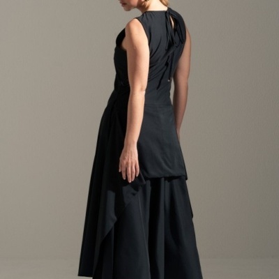 Vestido preto sem mangas com saia assimétrica e detalhe de laço