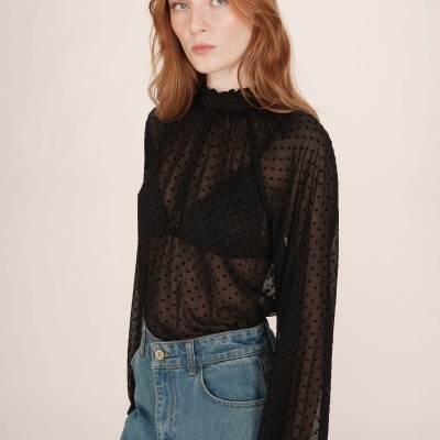 Blusa preta transparente com bolinhas e calças de ganga azul claro