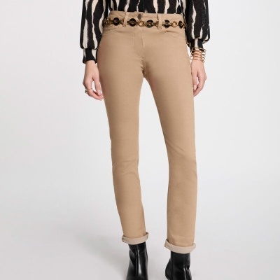 Calças castanhas justas com cinto com argolas douradas, bota preta de salto e camisola preta com padrão bege