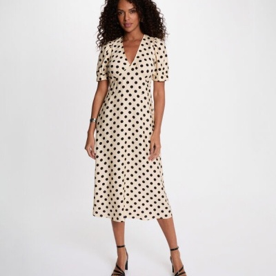 Vestido midi bege com bolinhas pretas e mangas bufantes em modelo feminino