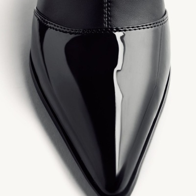 Sapato preto com biqueira afilada e brilho em fundo branco