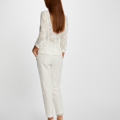 Conjunto feminino branco rendado com blusa e calças, sandálias brancas, vista traseira